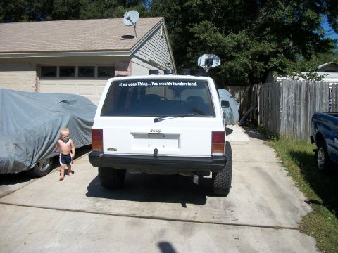1992 Jeep Cherokee - A white 1992 Jeep Cherokee is parked in a driveway with a child nearby.