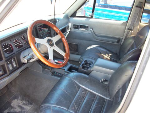 1992 Jeep Cherokee - Interior view of a 1992 Jeep Cherokee, an aftermarket steering wheel and leather seats.