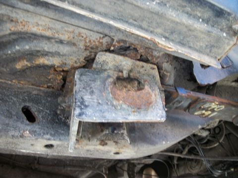 1992 Jeep Cherokee - Close-up of a heavily rusted frame bracket on the underside of a vehicle.