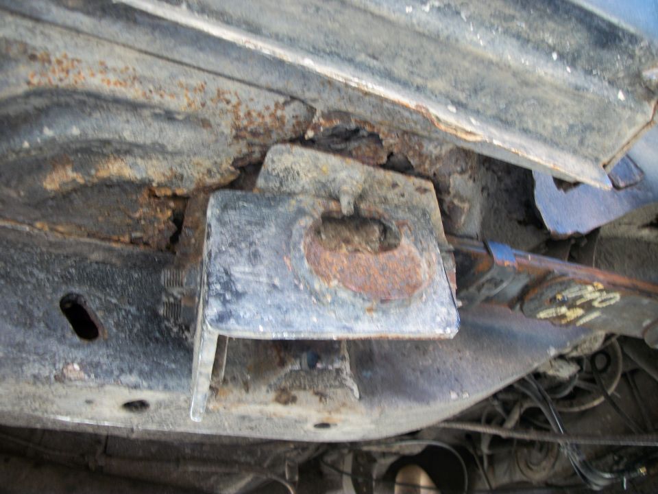 rusted frame bracket on underside of vehicle