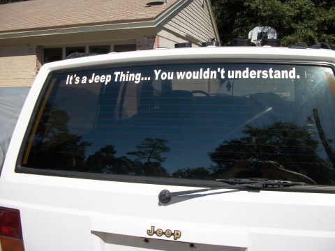 1992 Jeep Cherokee - A white Jeep Cherokee displays a popular decal on its rear window, with the brand's logo below.