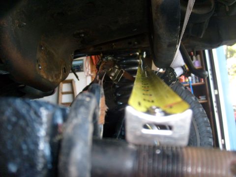 1986 Ford Bronco - Close-up of a tape measure being used on a vehicle's suspension system.