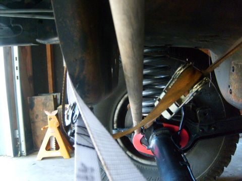 1986 Ford Bronco - Close-up view of a vehicle's undercarriage, focusing on suspension components and exhaust system.