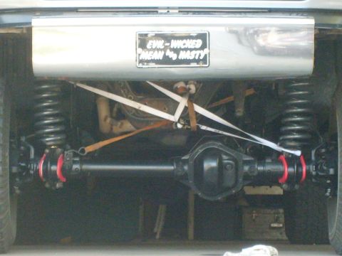 1986 Ford Bronco - Custom license plate on a vehicle's rear suspension system, reading 'EVIL-WICKED MEAN & NASTY'.
