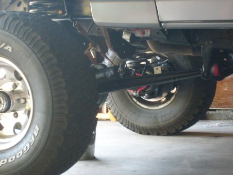 1986 Ford Bronco - Close-up view of a vehicle's undercarriage, showing suspension and tires.