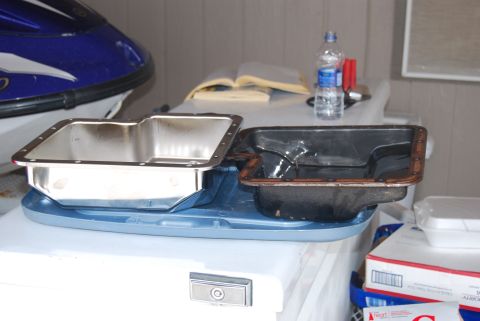 1982 Ford Bronco - A new oil pan sits next to an older, used one, possibly for comparison or from a vehicle.