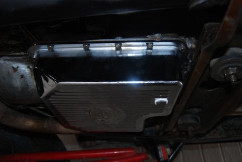 1982 Ford Bronco - Underside view of a shiny chrome transmission pan, likely an aftermarket upgrade.