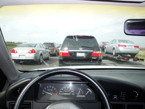 1989 Ford Taurus - View from inside a car during a highway traffic jam, showing other vehicles ahead.