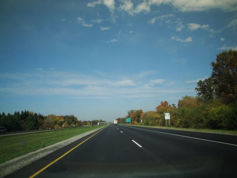 1989 Ford Taurus - A view from a vehicle traveling on a highway during autumn, with trees showing fall colors.
