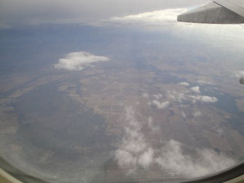 1989 Ford Taurus - View of agricultural fields and scattered clouds from an airplane window.
