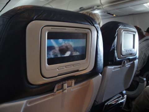 1989 Ford Taurus - Interior view of an airplane cabin, focusing on the seatback entertainment screens and the seating arrangement.