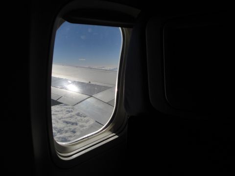 1989 Ford Taurus - Looking out the window of an airplane at the clouds and wing during flight.
