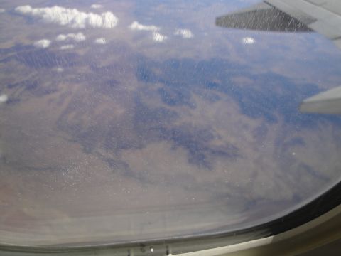 1989 Ford Taurus - A scenic view of clouds and mountainous terrain seen through an airplane window.