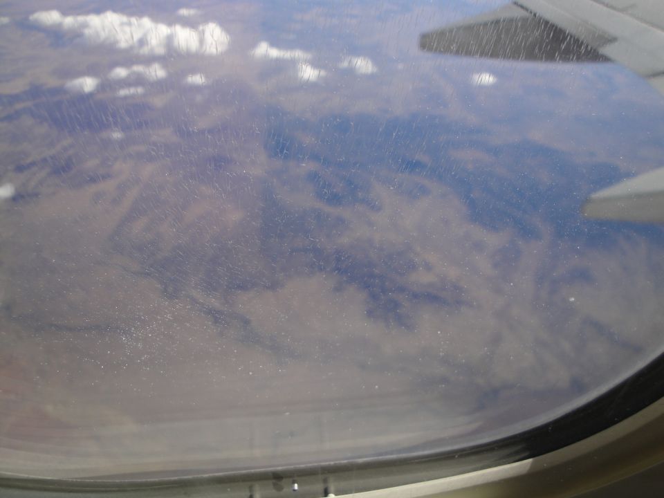 View of clouds and mountains from an airplane window