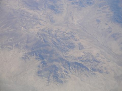 1989 Ford Taurus - Expansive desert terrain viewed from high altitude, showing geological formations and arid landscape.