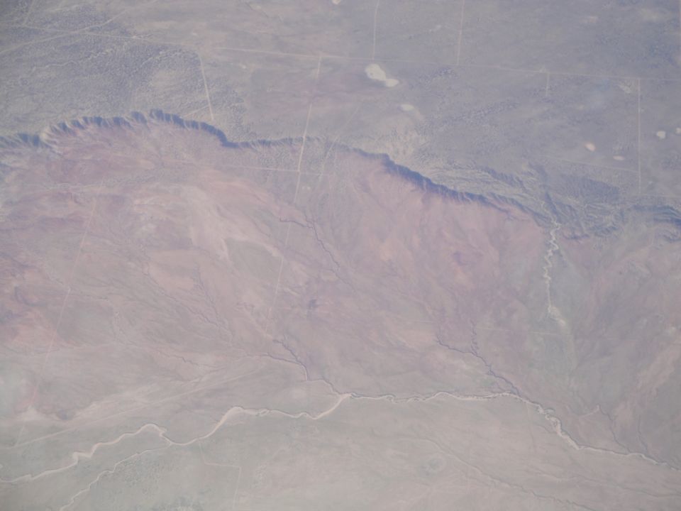 Aerial view of a desert landscape with a canyon and dry riverbeds
