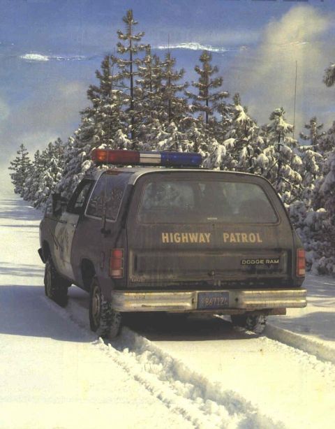 1987 Dodge 1500 - A 1987 Dodge Ram, marked as Highway Patrol, is seen from the rear in a snow-covered environment.