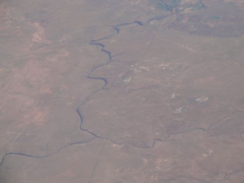 1989 Ford Taurus - An aerial perspective captures a meandering river cutting through arid terrain dotted with small settlements.