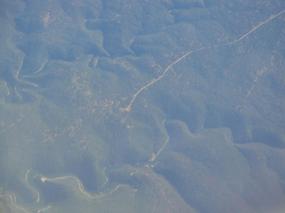 Aerial view of forested hills with a winding road