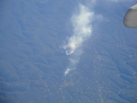1989 Ford Taurus - Aerial view of smoke plumes over a vast, tree-covered mountainous landscape.
