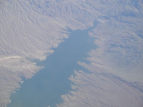 1989 Ford Taurus - An aerial perspective captures a body of water with an irregular shoreline, bordered by dry, mountainous terrain.