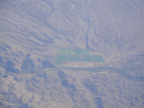 1989 Ford Taurus - An aerial perspective reveals cultivated land amidst a vast, arid mountain range.