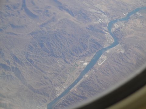 1989 Ford Taurus - An aerial perspective captures a winding river cutting through a mountainous landscape, with human settlements visible on its shores.
