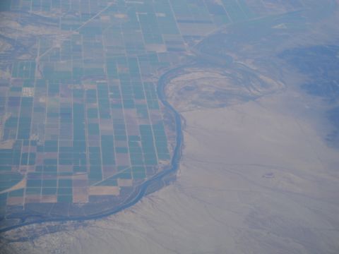1989 Ford Taurus - An aerial perspective shows a river cutting through agricultural fields and desert terrain.