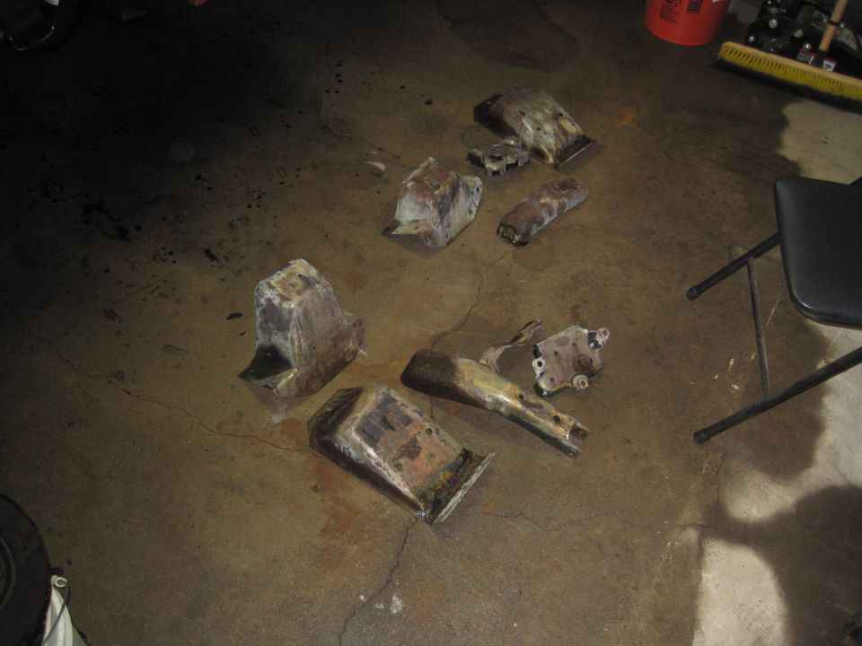 Scattered rusty vehicle suspension components on a concrete floor