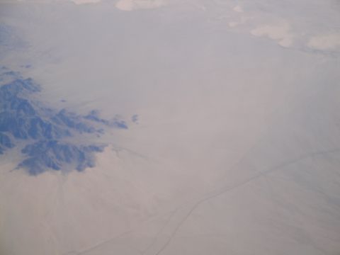 1989 Ford Taurus - Desert landscape with mountains and a road visible from above.