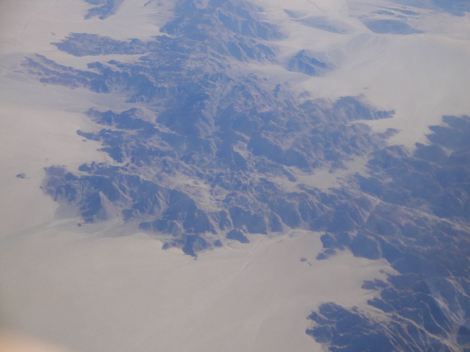 Aerial view of a desert mountain range with sandy plains