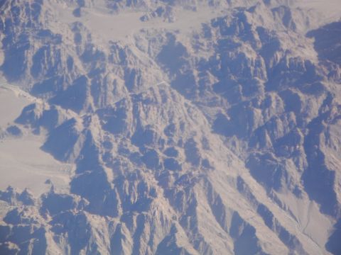 1989 Ford Taurus - The vast, rocky expanse of a desert mountain range seen from above.