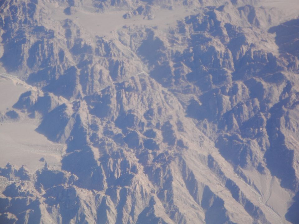 Aerial view of , arid mountains with shadows cast across the terrain