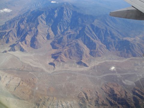 1989 Ford Taurus - View from an airplane window shows a vast mountain range and arid landscape below.