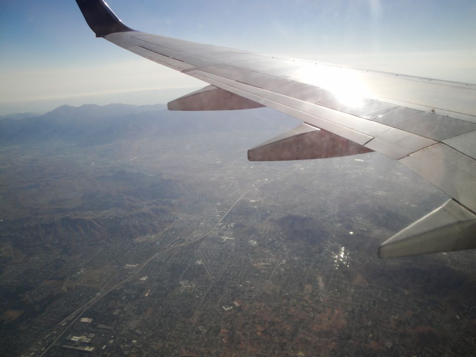 View from airplane window showing wing and landscape below