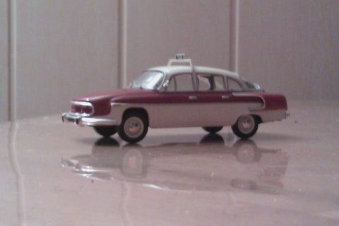 1991 Ford LTD Crown Victoria - A model taxi with a maroon and white paint scheme sits on a reflective surface.