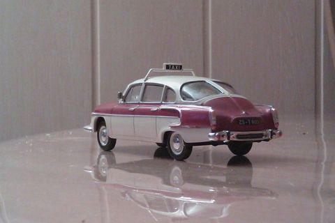 1991 Ford LTD Crown Victoria - A model taxi car with a two-tone paint scheme and a roof-mounted taxi sign is displayed.