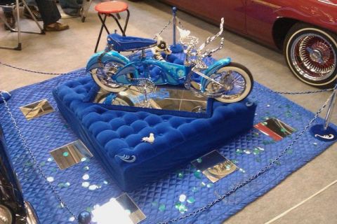 1991 Ford LTD Crown Victoria - A custom motorcycle is presented on a velvet display at a show.