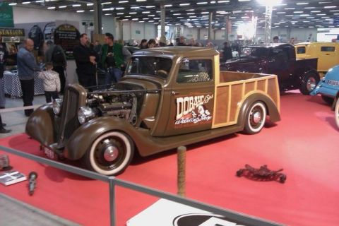 1991 Ford LTD Crown Victoria - A custom hot rod pickup truck with wood paneling is displayed indoors, with other vehicles nearby.