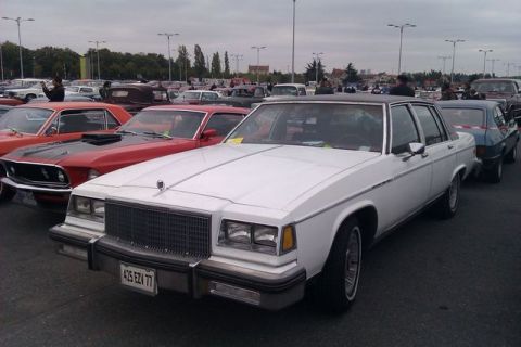 1991 Ford LTD Crown Victoria - A white sedan is parked in a lot with other vehicles visible.