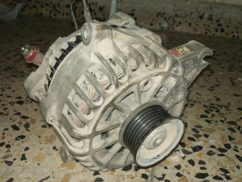 1998 Ford Crown Victoria - A dusty automotive alternator with its pulley is shown resting on a speckled tiled surface.
