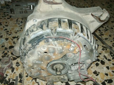 1998 Ford Crown Victoria - Close-up of a used alternator, showing internal components and external wear.