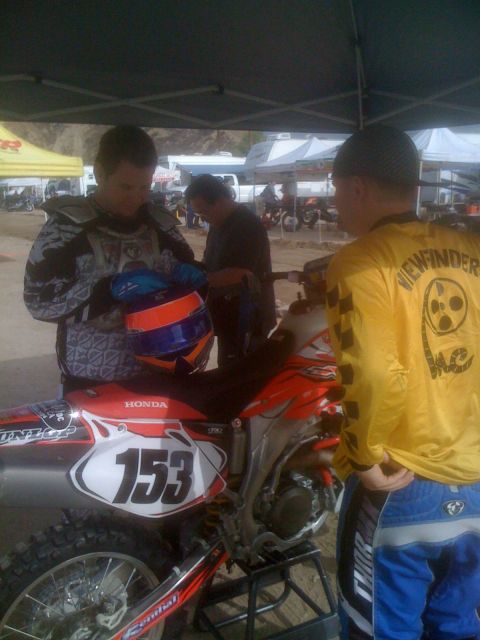 1968 Ford Mustang - A dirt bike with number 153 is parked under a tent with people around it.
