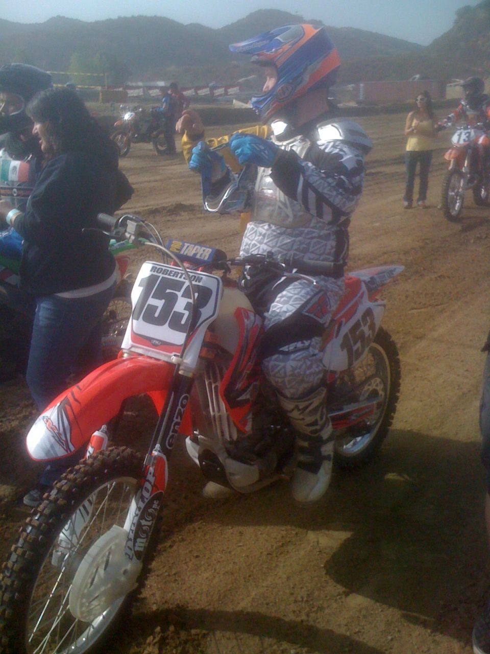 Motocross rider with number 153 on dirt bike