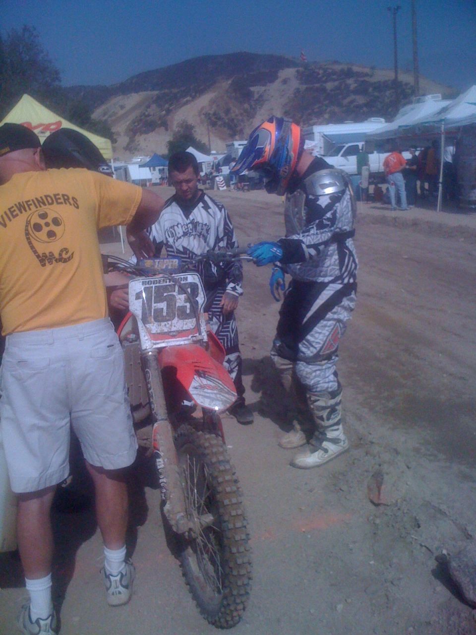 Motocross motorcycle with number 153 and riders in racing gear