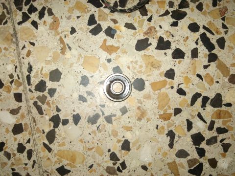 1998 Ford Crown Victoria - A single bearing is pictured on a terrazzo floor, with text visible on the bearing itself.