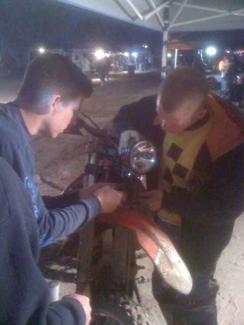 1968 Ford Mustang - Mechanics attend to the front end of a motorcycle, focusing on the fender and headlight.