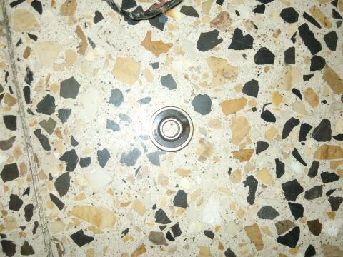 1998 Ford Crown Victoria - A single metal bearing is pictured on a terrazzo floor.