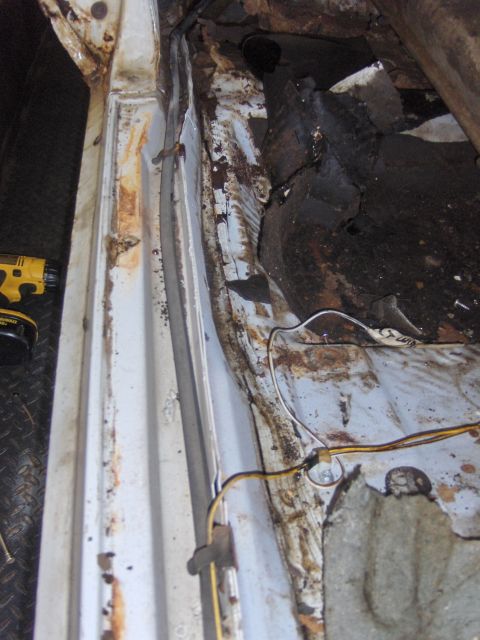 1972 Chevrolet Camaro - The interior floor of the vehicle shows significant rust and deterioration, indicating a need for repair.