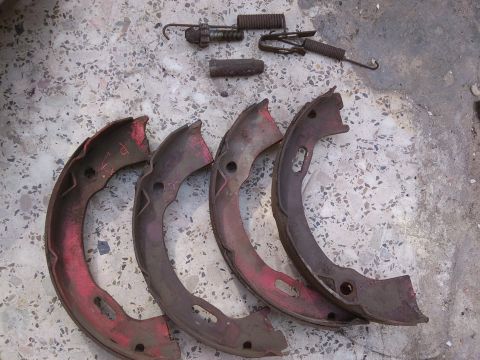 1998 Ford Crown Victoria - These are worn brake shoes and springs, likely removed during maintenance or repair.